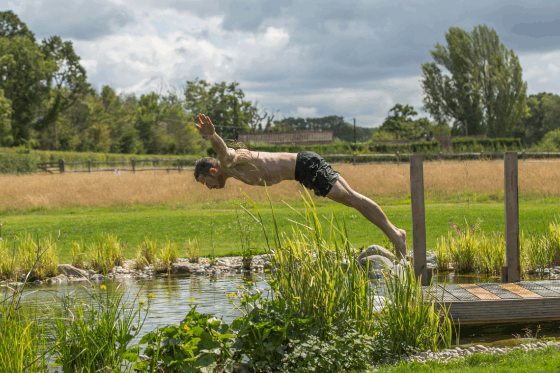 person diving into swimming pond